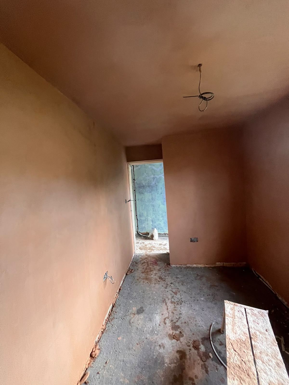 Narrow hallway with freshly re-skimmed plaster walls and ceiling