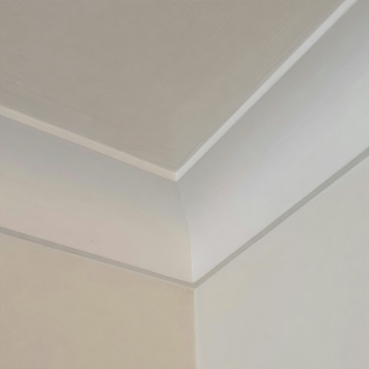 White plaster coving at a ceiling corner, freshly finished