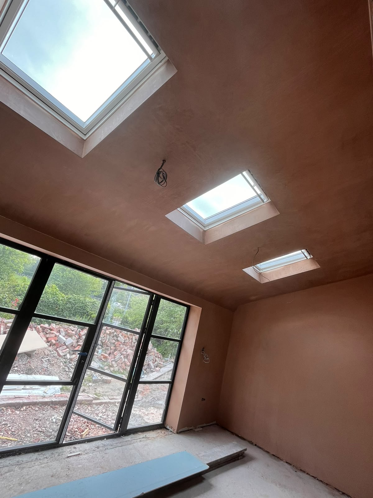 Plastered roof-window and wall-window reveals in a newly skimmed extension
